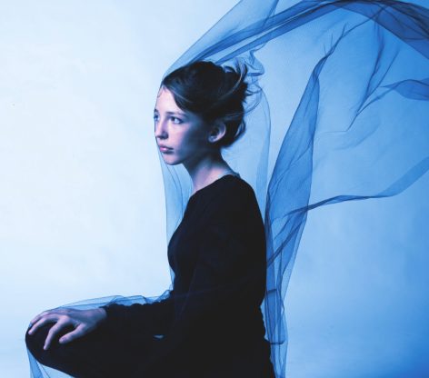 editorial portrait of a girl with tulle blowing around her